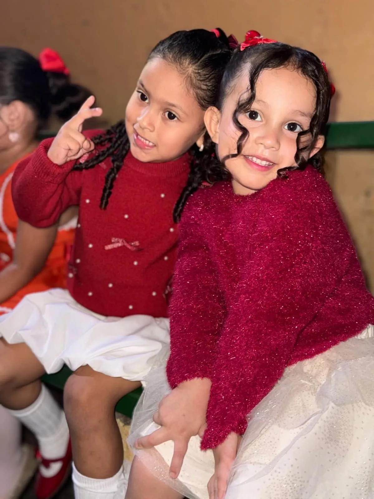 Dos alumnas de kinder sonríen juntas durante un evento escolar