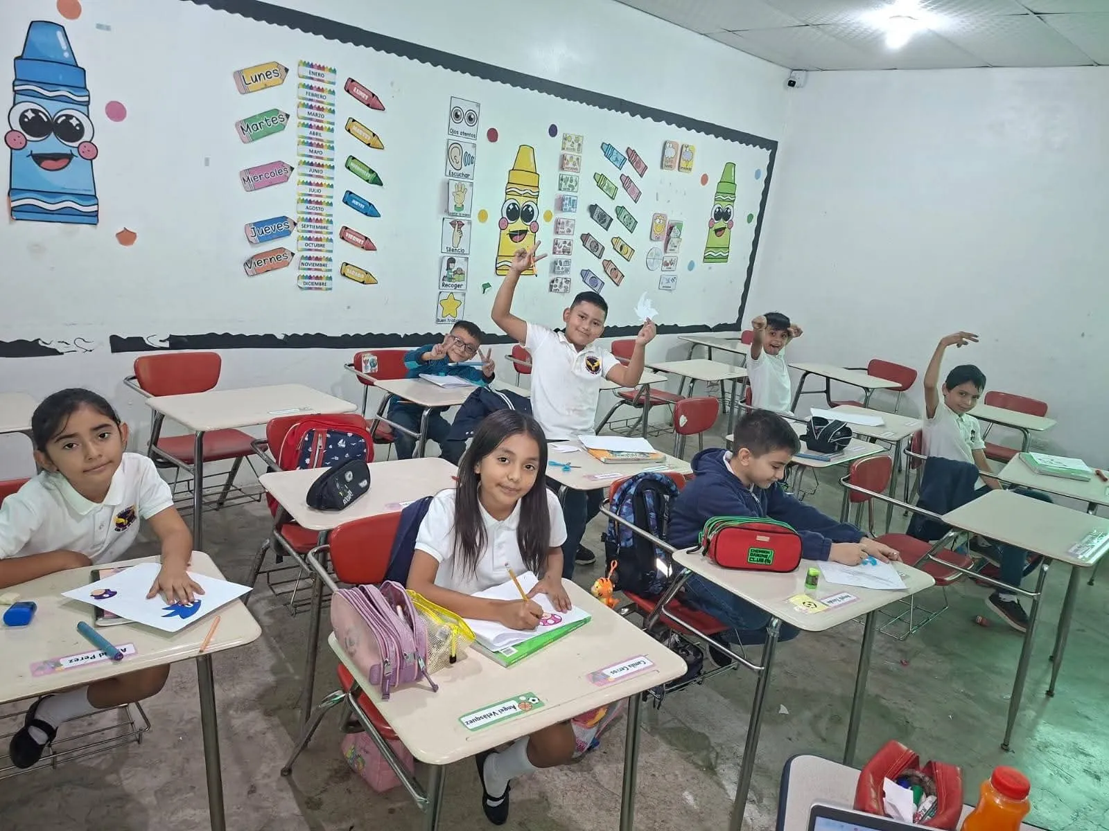 Alumnos de Eagles Academy levantan la mano durante una clase