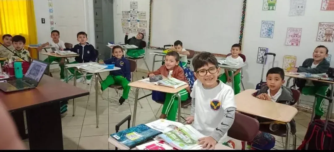 Niños de pre básica leyendo sus libros en el salón de clases