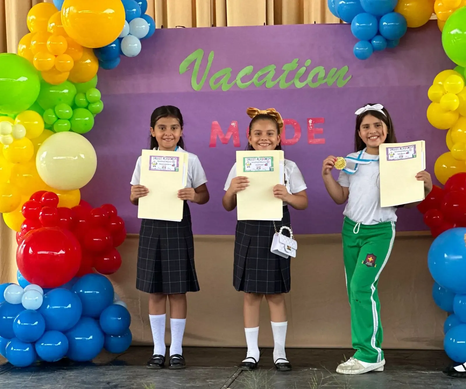 Alumnas muestran sus diplomas de reconocimiento