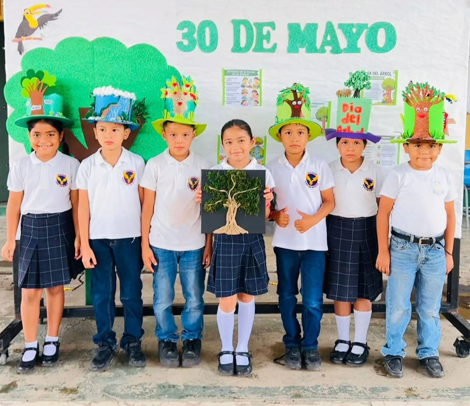 Alumnos con sombreros de árboles celebran el Día del Árbol, 30 de mayo