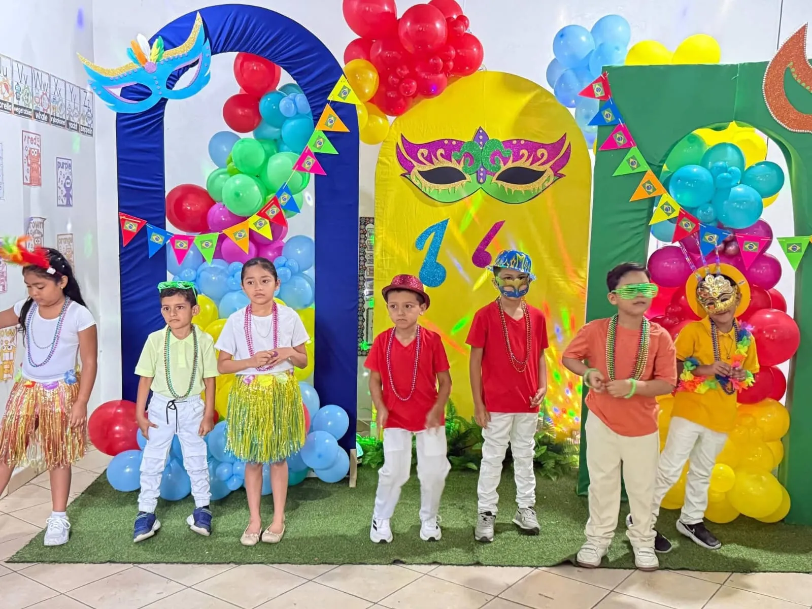 Alumnos con máscaras y collares de carnaval en el stand de Brasil